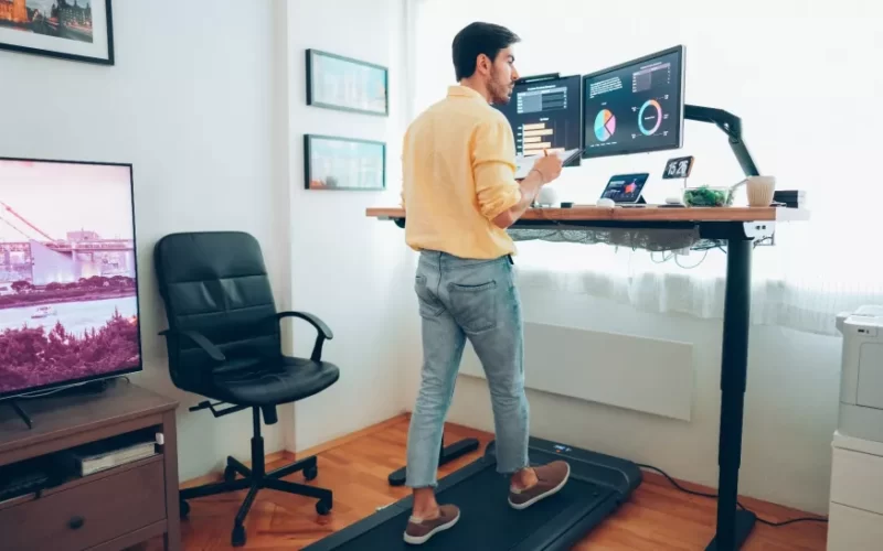 Man using walking pad treadmill from his home office